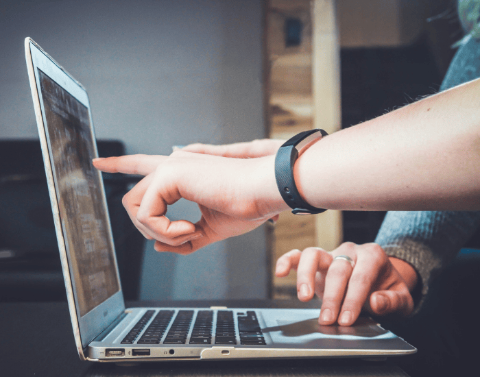 two people pointing at computer screen